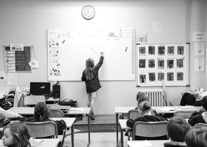 Photo dans la classe avec un élève au tableau